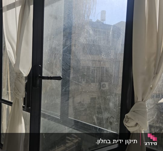 חלון פתוח עם וילונות לבנים קשורים